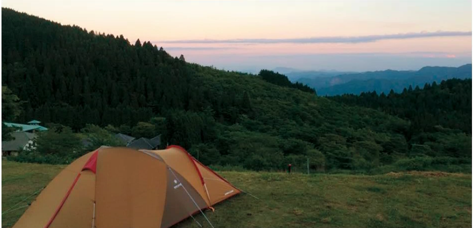 朝焼けを背景に壮大な自然の手前にテントがある写真